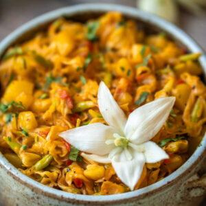 Traditional Costa Rican picadillo with yucca flowers and potatoes, beautifully served in a bowl and topped with a blooming yucca flower