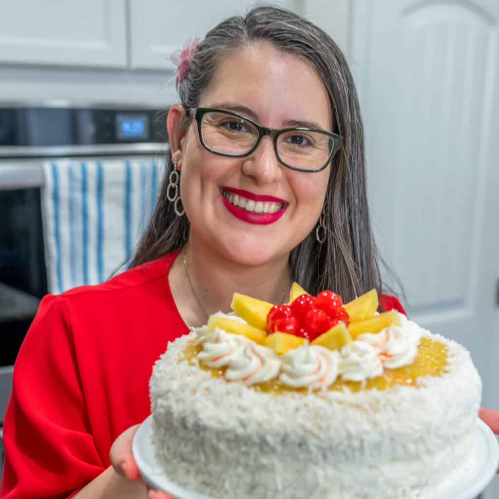 Picture shows the face of Mara creator of The Latin Spoon, she is wearing a red blouse, black glasses and a big smile