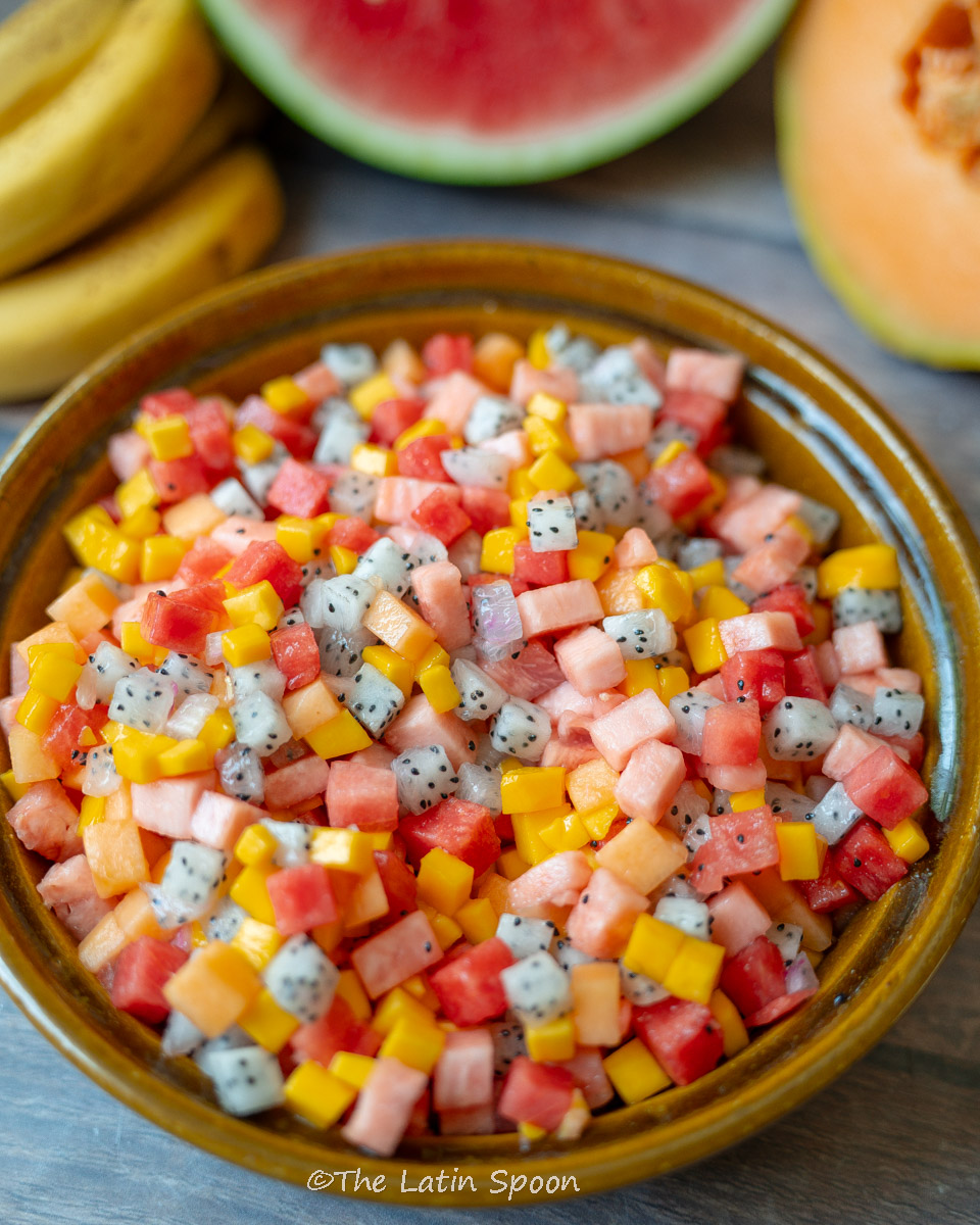 Bowl of mixed tropical fruit salad with mango, pineapple, watermelon, and melon pieces."