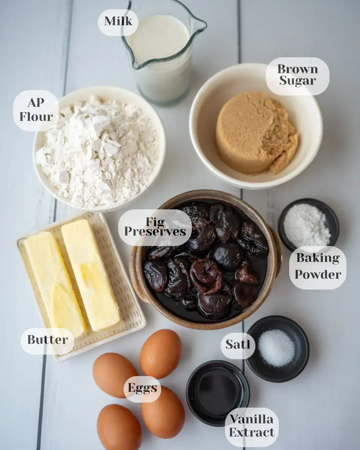 Overhead view of all the ingredients used to make the fig cake, each labeled with its name.