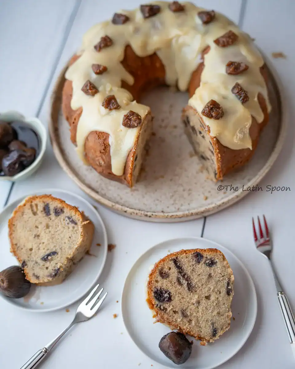 Overhead shot of the fig cake with two missing slices, beside the large plate are those two slices served on individual plates with forks next to them.