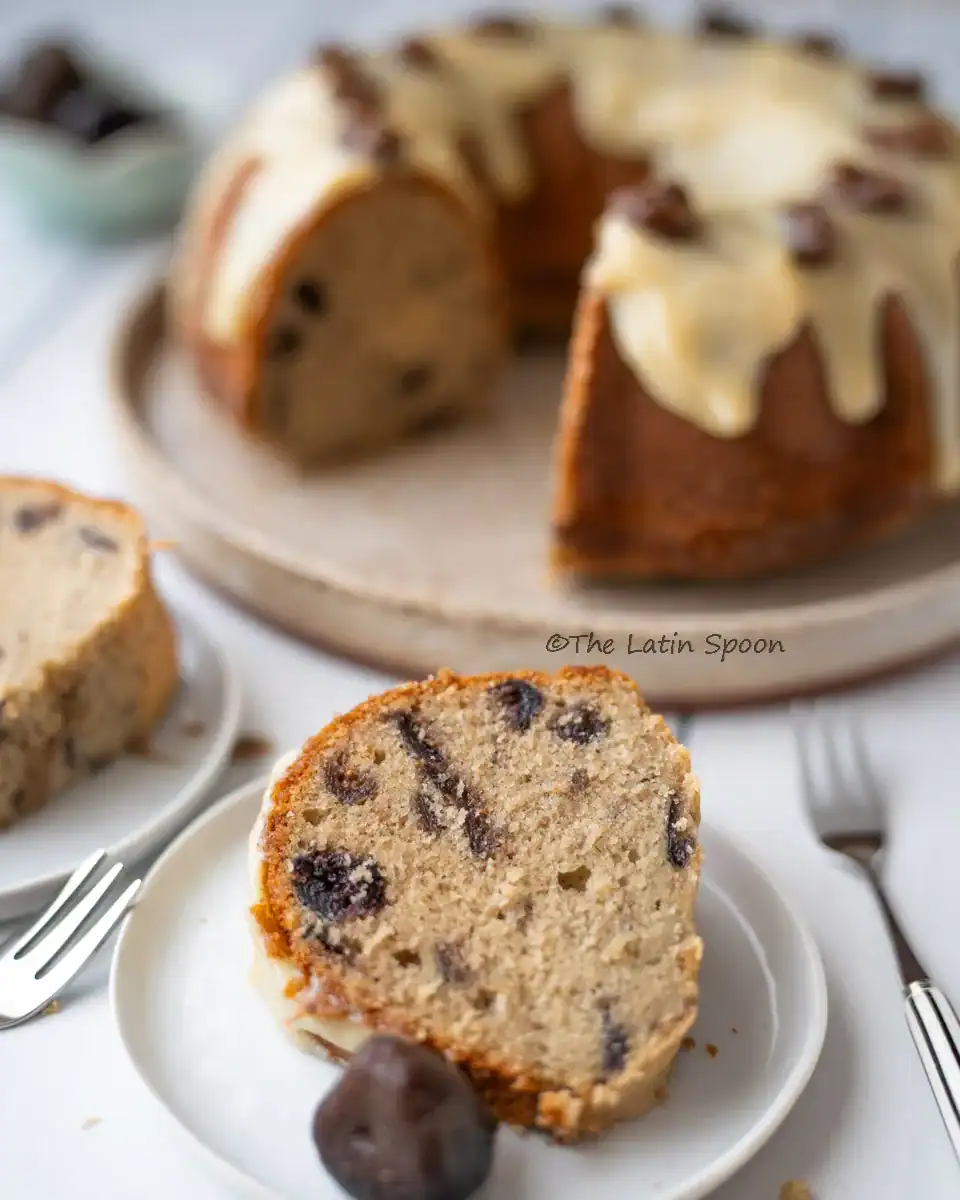 Two slices of fig cake in the front, with the main cake in the back showing where those slices were cut, and a fork placed beside them