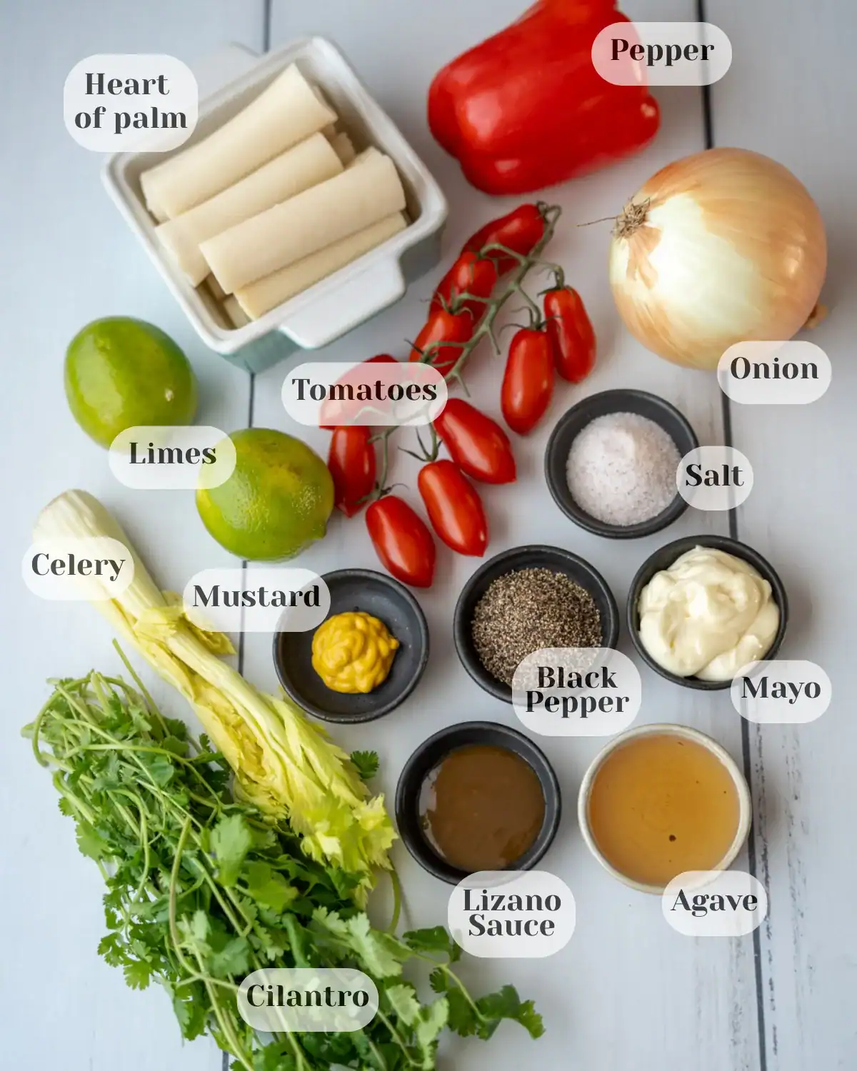 Overhead photo showing all the ingredients used for the heart of palm salad, each labeled with its name.