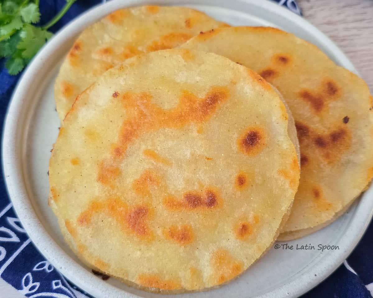 A plate with three "Costa Rican prensadas" placed on a traditional cloth