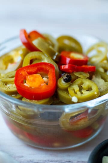A small container holding slices of jalapeño chili.