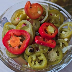 A small container holding slices of jalapeño chili.