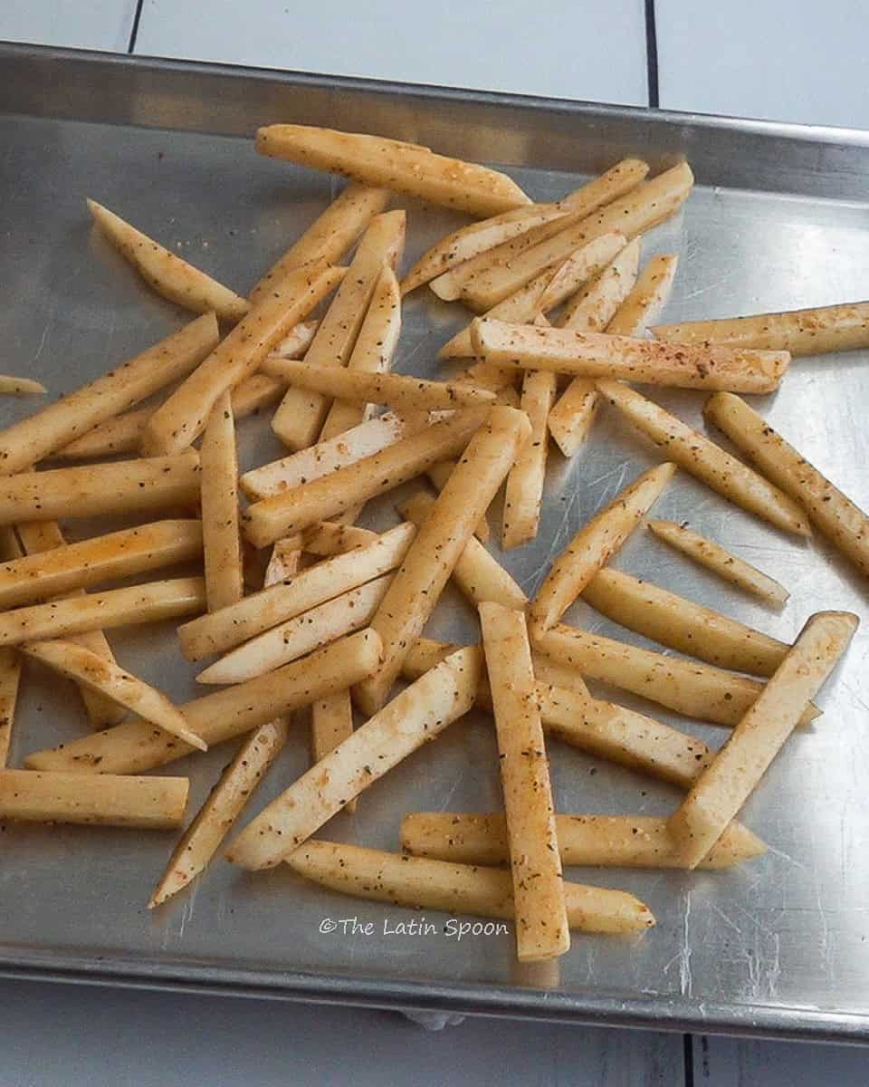 Seasoned potato strips on an aluminum tray