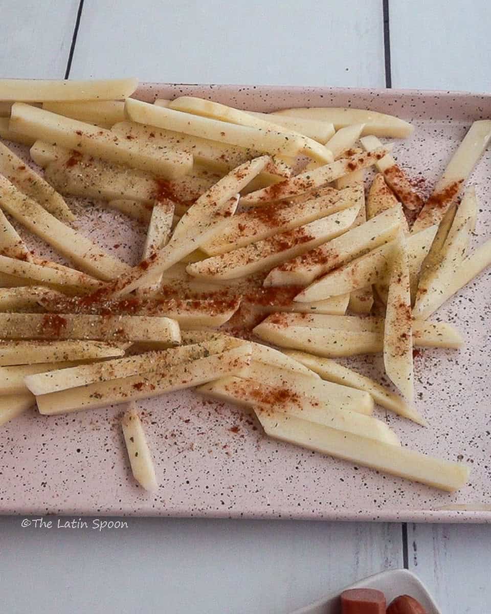 Potato strips on a tray sprinkled with paprika.