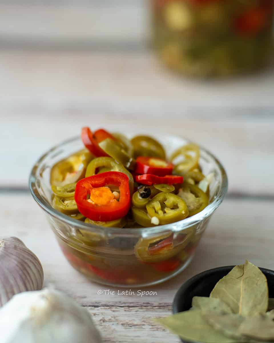 A small container holding slices of pickled jalapeños.