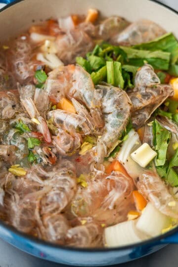 A pot containing shrimp shells and vegetables.