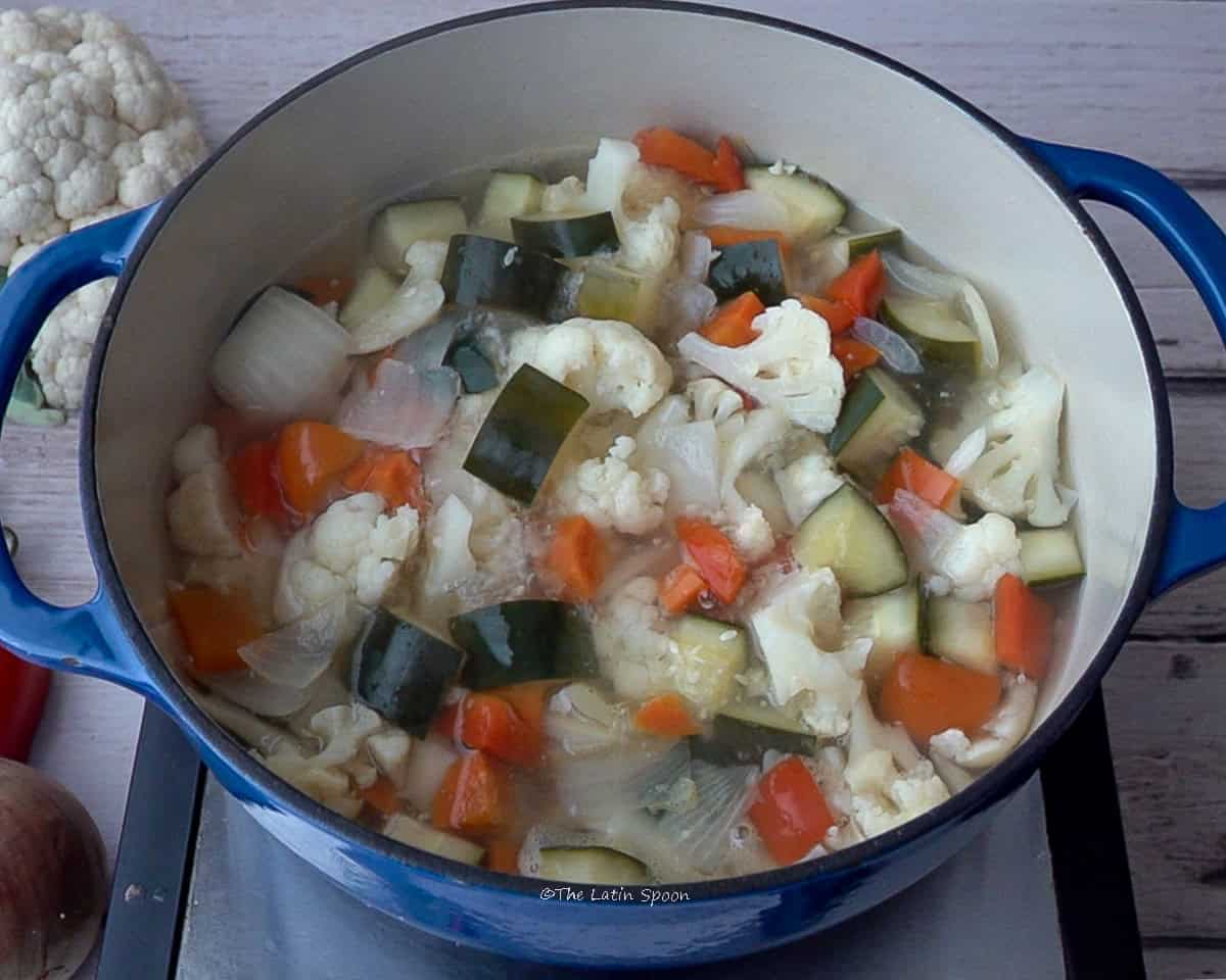 A pot with diced vegetables and water.