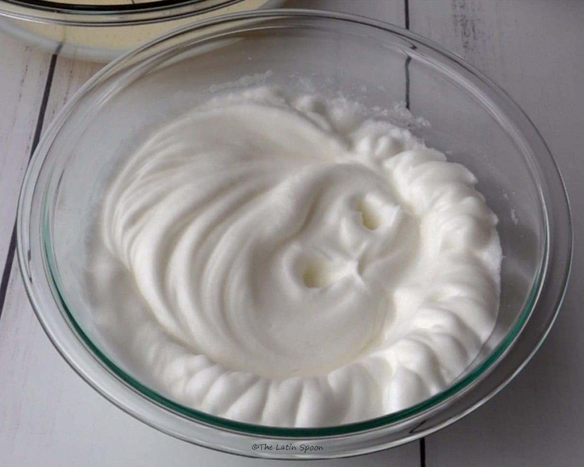 A bowl filled with whipped egg whites that look light and fluffy.