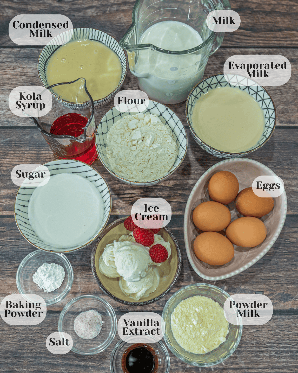 Containers with the ingredients for Churchill tres leches cake arranged on a countertop, including condensed milk, regular milk, evaporated milk, all-purpose flour, kola syrup, sugar, eggs, ice cream, baking powder, salt, vanilla extract, and powdered milk.