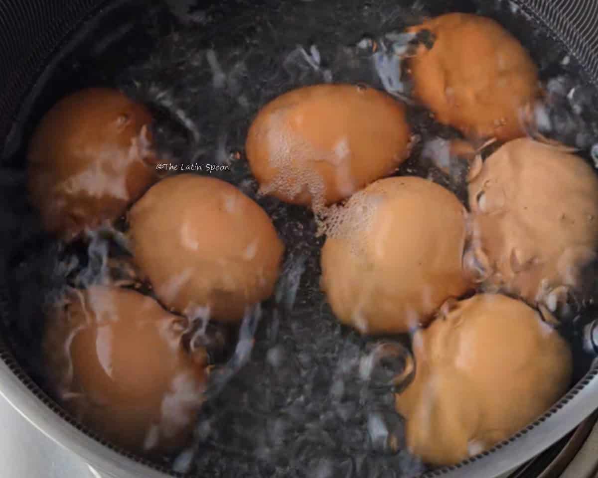 A pot filled with water and boiling eggs.
